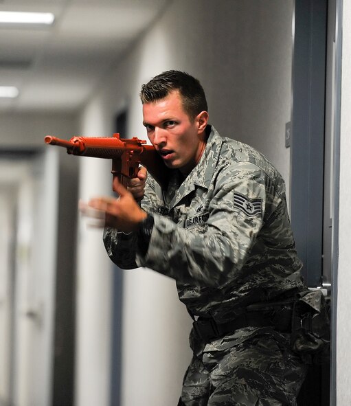 Staff Sgt. Brian Lecates, 436th Security Forces Squadron, moves quickly down a hallway while responding to an active shooter scenario at Building 520 on Aug. 1, 2014, at Dover Air Force Base, Del. Lecates used a rubber-gun instead of a real weapon during training.  (U.S. Air Force photo/Greg L. Davis)