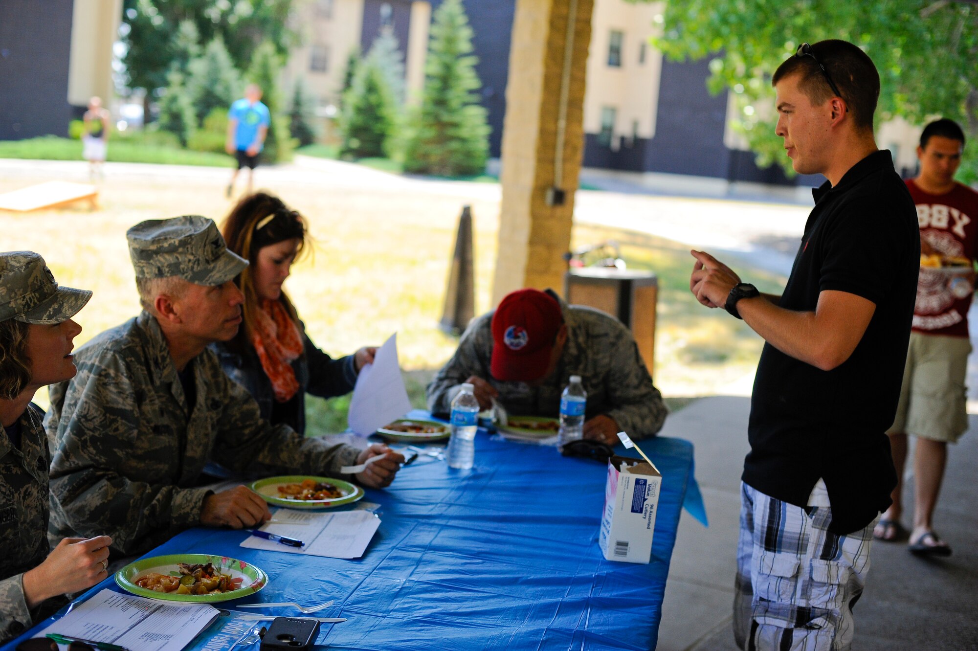 Airman 1st Class David Cairns, 341st Civil Engineer Squadron structural craftsman (right), explains how he made his signature dish to a panel of judges during Malmstrom’s Fit Food Festival Aug 1. During the competition, contestants had one hour to cook their favorite entrée before submitting it to be critiqued on nutritional value, ease of preparation and taste. (U.S. Air Force photo/Airman 1st Class Collin Schmidt)