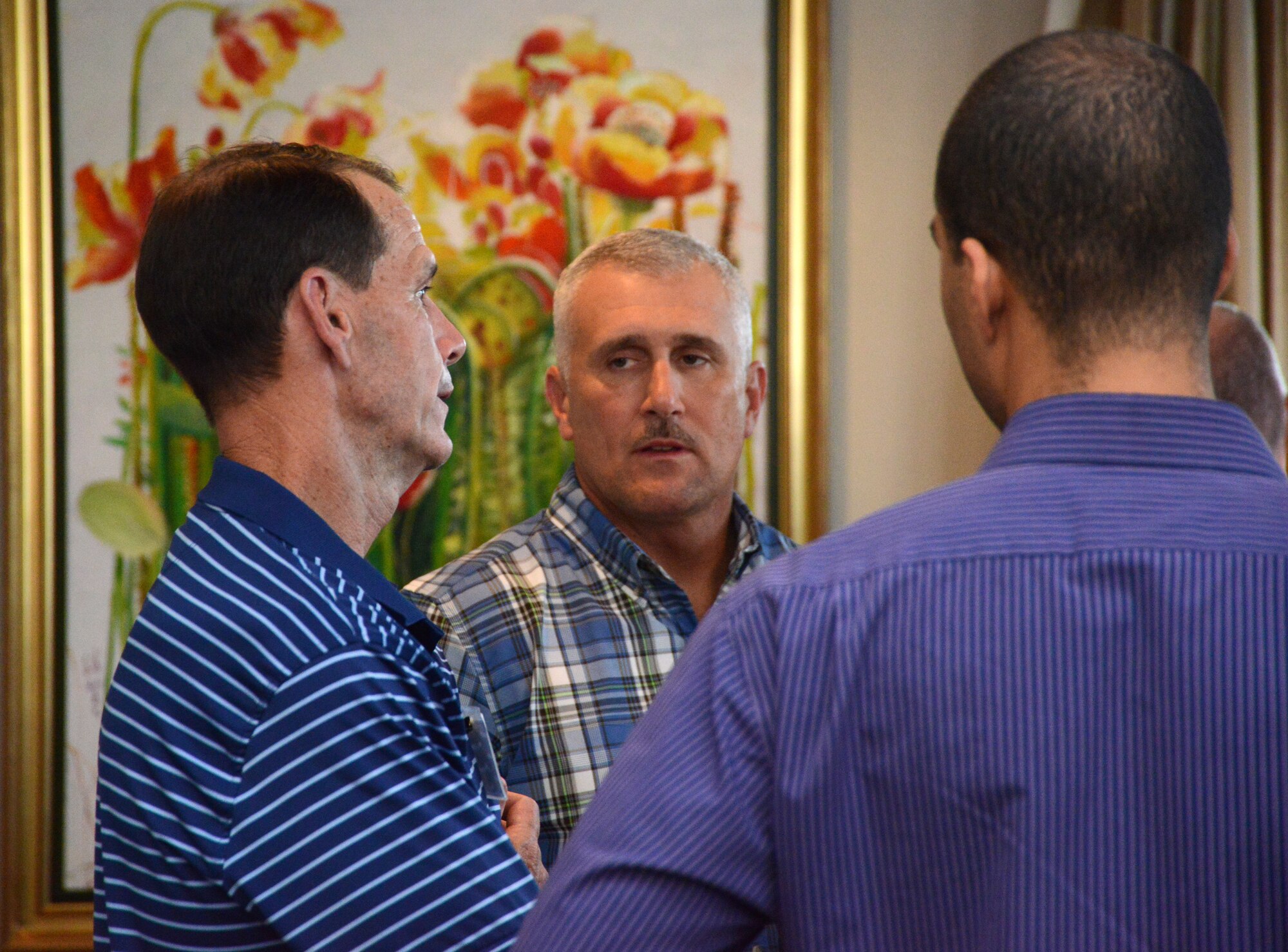 Lt. Gen. Stanley E. Clarke III, Director of the Air National Guard, talks with Master Sgt. David Coker and Senior Airman Christian Goldsmith, two of the ANG's Outstanding Airmen of the Year during a dinner hosted at his home on Joint Base Anacostia Bolling, Washington D.C. Aug. 4, 2014. The Airmen are in the National Capitol Region for Focus on the Force Week, providing the perspective of the enlisted Airmen to Air Guard leadership. (U.S. Air National Guard photo by Senior Airman John E. Hillier/Released)