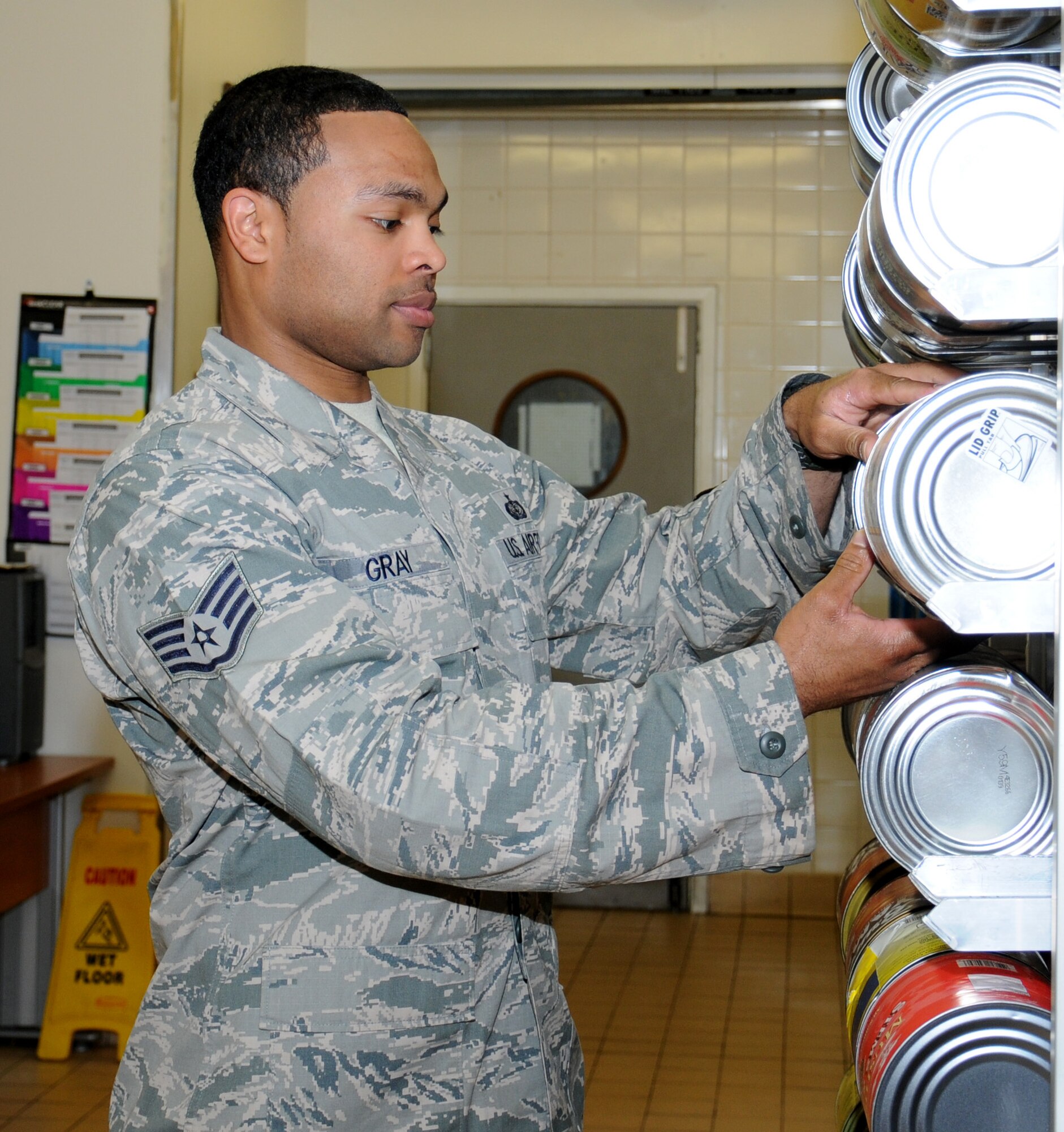 U.S. Air Force Staff Sgt. Justin Gray, 100th Force Support Squadron NCO in charge of the storeroom from Oakland, Calif., performs a stock check of canned goods at the Gateway Dining Facility July 31, 2014, on RAF Mildenhall, England. Strict control is needed in the storage room for financial compliance. (U.S. Air Force photo/Gina Randall/Released)