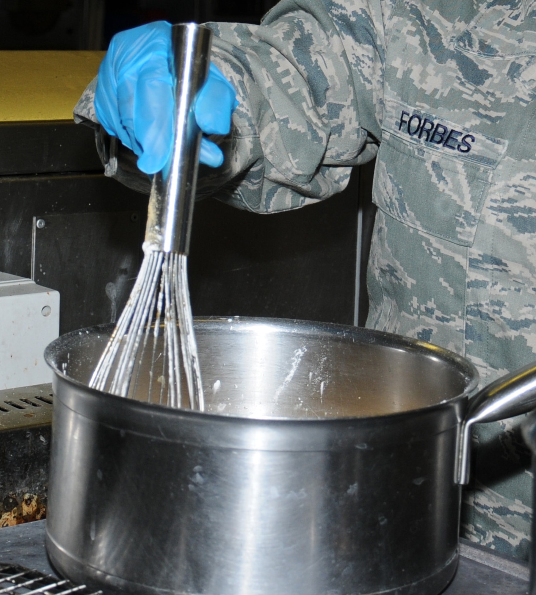 U.S. Air Force Staff Sgt. Shellisa Forbes, 100th Force Support Squadron Services technician from St. Thomas, U.S. Virgin Islands, prepares a sauce July 31, 2014, on RAF Mildenhall, England. The Gateway Dining Facility staff offers a variety of pre-made and cooked-to-order foods available for breakfast, lunch, dinner and a midnight meal. (U.S. Air Force photo/Gina Randall/Released)