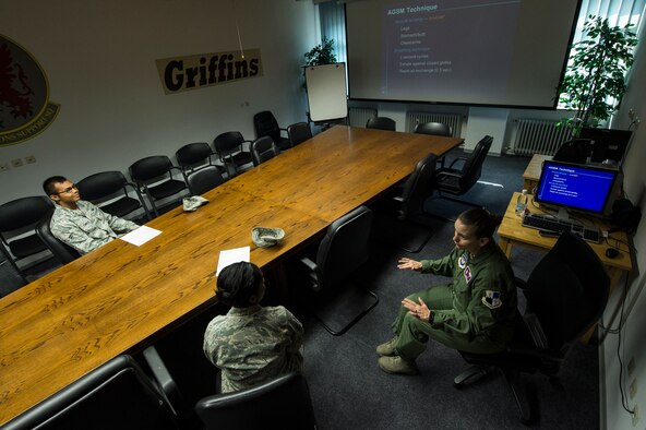 U.S. Air Force Maj. Christy Zahn, 52nd Operations Support Squadron aerospace and operational physiology training team flight commander from Los Alamos, N.M., briefs about the physiological effects of flying to Airmen prior to a familiarization flight July 28, 2014, at Spangdahlem Air Base, Germany. Members of the aerospace physiology training team operate a reduced oxygen breathing device, which is used to teach pilots how combat hypoxia. (U.S. Air Force photo by Senior Airman Rusty Frank/Released)