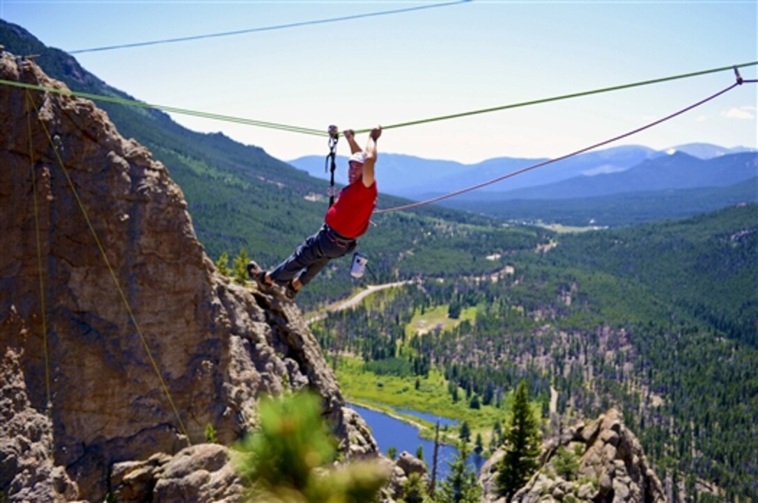 Mike Oldham, a Navy veteran, pauses as he experiences a Tyrolean traverse on the top of the area known as "Jurassic Park” during a USO-sponsored rock-climbing camp at Estes Park, Colo., Aug. 2, 2014. USO partnered with Team Red, White and Blue to provide opportunities for veterans. A Tyrolean traverse is a method of crossing through free space between two high points on a rope. 