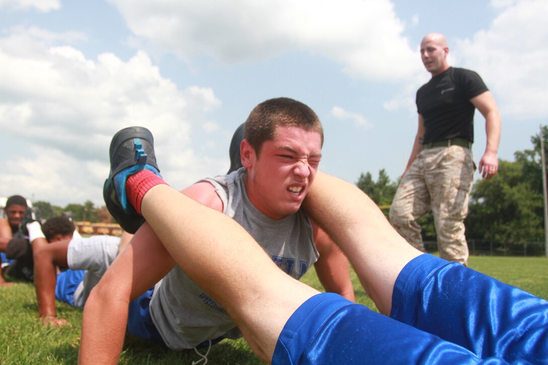 Justin Hixson, a junior at Xenia High School and safety for the Xenia High School football team, completes a squad pushup during the physical portion of a leadership seminar at the high school in Xenia, Ohio, July 31, 2014. The seminar was conducted by Marines from Recruiting Station Charleston with the purpose of developing the leadership abilities of the football team by teaching Marine Corps values. (U.S. Marine Corps photo by Sgt. Tyler Hlavac/Released)