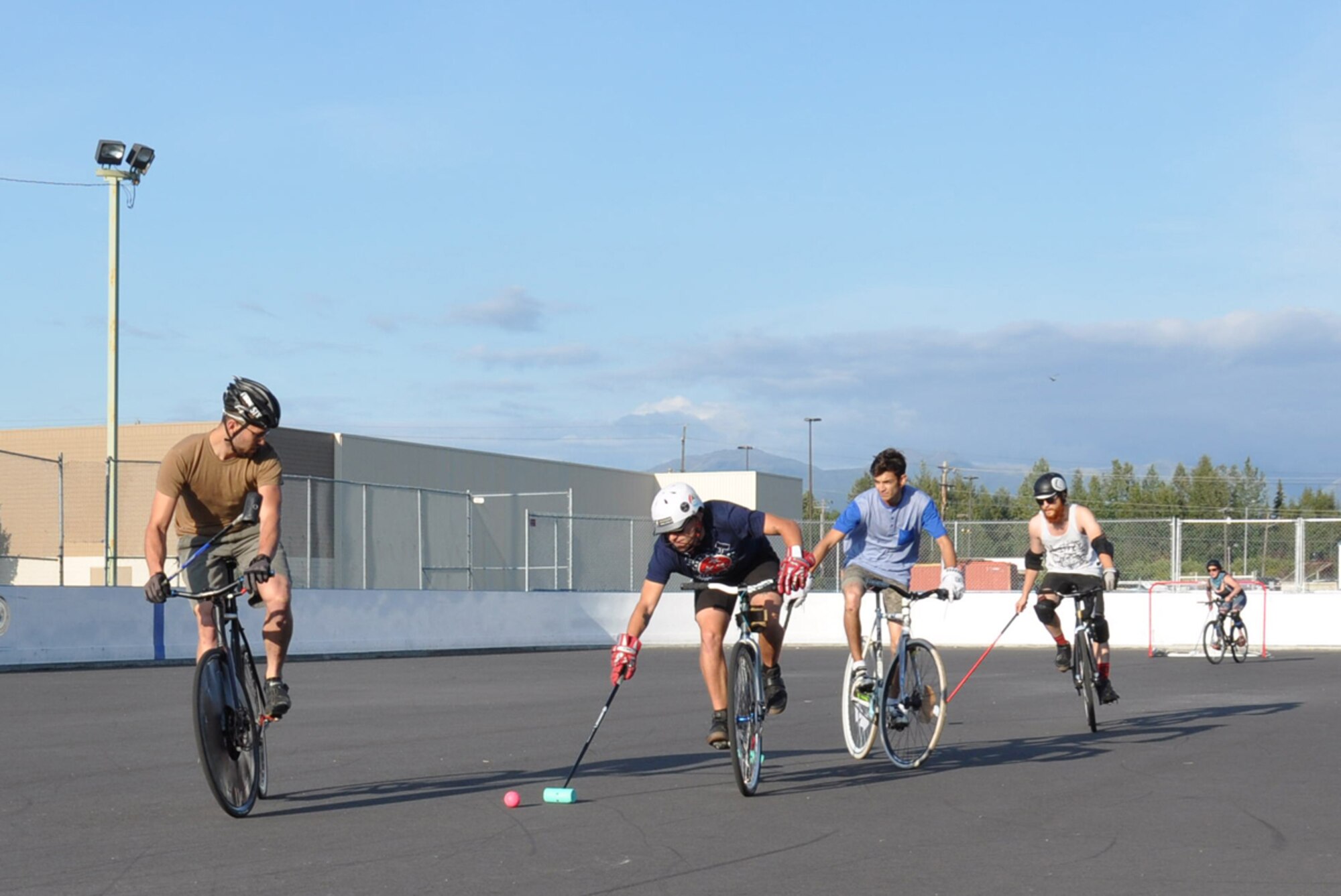 Staff Sgt. Jonathan MacPherson (blue shirt), races toward the goal with defenders in hot pursuit during a bike polo game July 31, 2014 in Anchorage, Alaska. MacPherson is a 673rd Logistics Readiness Squadron fuels service center controller who recently qualified to compete in the World Hardcourt Bike Polo Championships in Montpellier, France, at the end of August. (U.S. Air Force photos/Staff Sgt. Wes Wright)