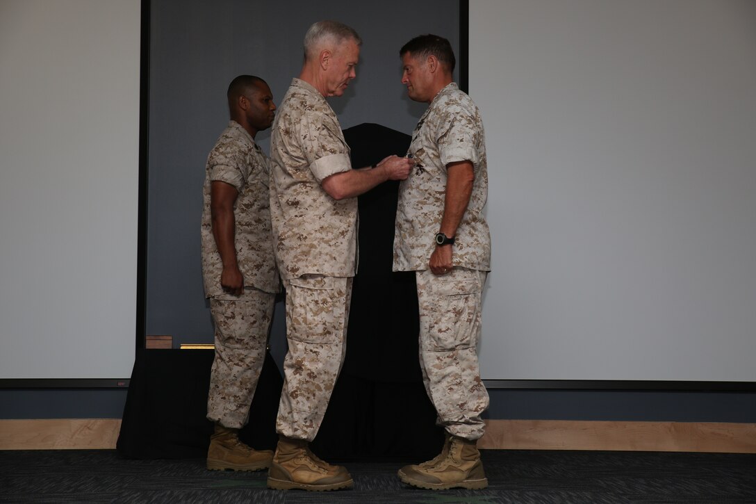 Commandant of the Marine Corps Gen. James F. Amos awards Maj. Gen. Mark A. Clark, the outgoing Marine Corps Forces Special Operations Command commander, the Distinguished Service Medal during the MARSOC change of command ceremony aboard Stone Bay at Camp Lejeune, N.C., Aug 6, 2014. Clark passed command to Maj. Gen. Joseph L. Osterman, during the ceremony.