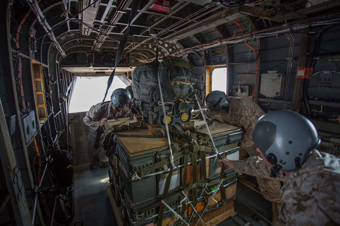 Marine parachute riggers with 1st Marine Logistics Group prepare to deploy a palletized load during the Joint Precision Airdrop System (JPADS) testing conducted Aug. 1 at the U.S. Army Yuma Proving Ground. The system being evaluated utilizes a series of palletized loads with parachutes on them that are guided via GPS inputs to very precise locations on the ground. 