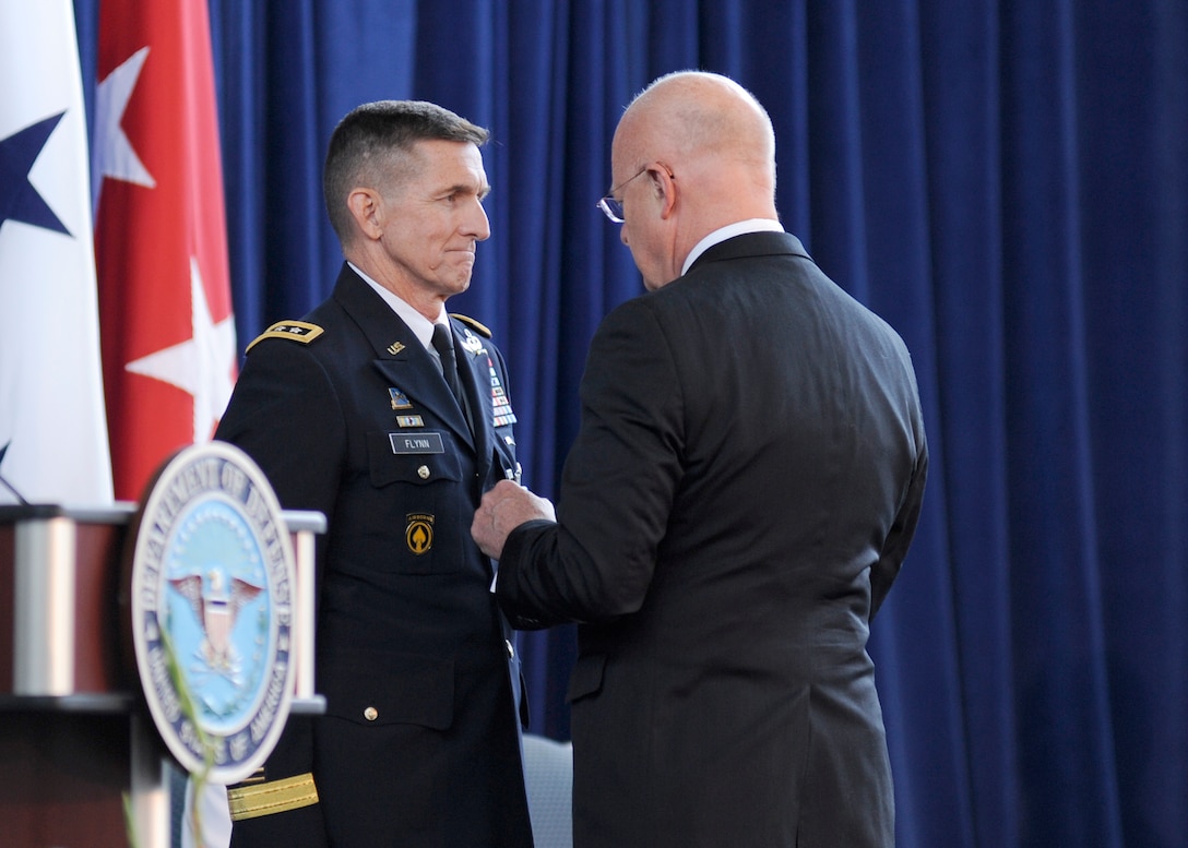 Director of National Intelligence James Clapper awards DIA Director Lt. Gen. Michael Flynn the National Intelligence Distinguished Service Medal during Flynn's retirement ceremony Aug. 7.