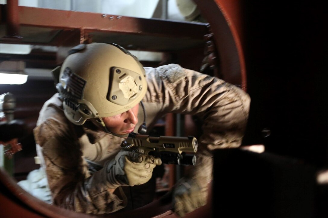 A Marine with the reconnaissance detachment, 11th Marine Expeditionary Unit, clears under the engine of the Reuben James as part of a visit, board, search and seizure training exercise at Naval Base Pearl Harbor, Hawaii, July 28, 2014. The 11th MEU and Makin Island Amphibious Ready Group are deployed as a sea-based, expeditionary crisis response force capable of conducting amphibious missions across the full range of military operations. (U.S. Marine Corps photo by  Lance Cpl. Evan R. White/Released)