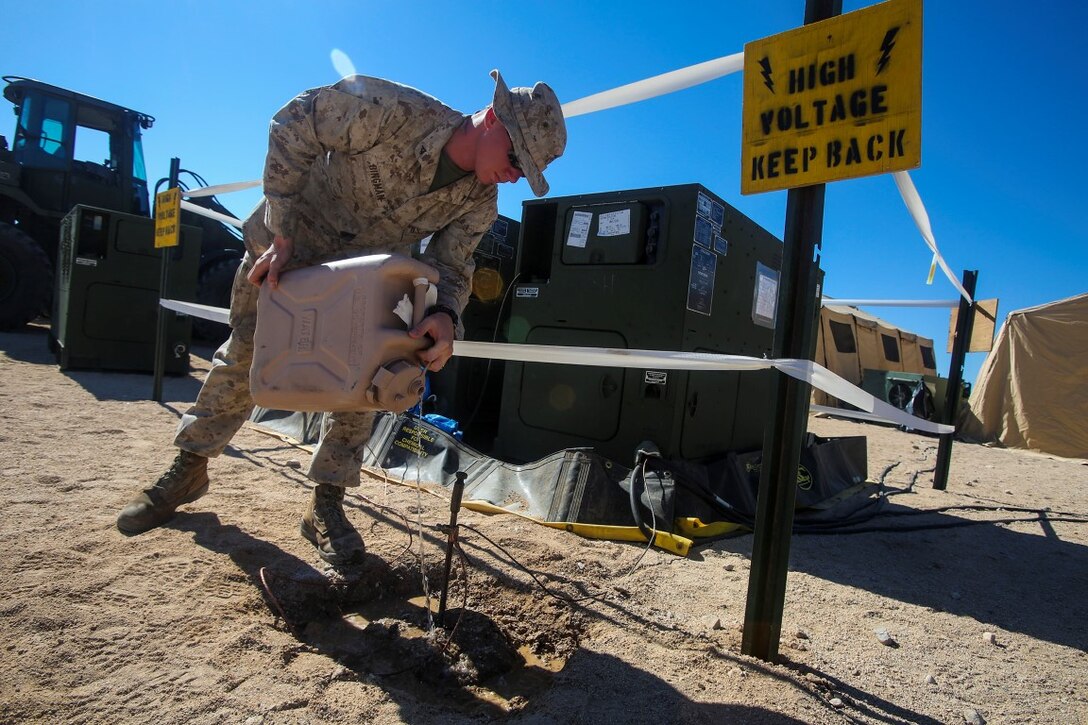 Lance Cpl. Elijah Bingman, an electrician generator operator with 1st Brigade Headquarters Group, Engineers, 1st Marine Expeditionary Brigade from Joplin, Mo., waters the grounding area of a MEP-1060 Generator Set, during Large Scale Exercise 2014 aboard Marine Corps Air Ground Combat Center Twentynine Palms, Calif., Aug. 6, 2014. LSE-14 is a bilateral training exercise being conducted by 1st MEB to build U.S. and Canadian forces’ joint capabilities through live, simulated, and constructive military training activities from Aug. 8-14. 