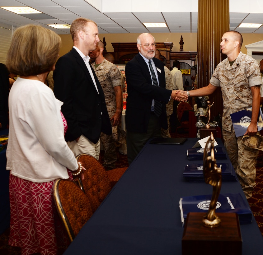 Staff Sgt. Zane Zertuche, radio technician, Marine Corps Logistics Command, speaks with representatives from Deerfield Windsor School June 30 during the first Military Child Educational Summit held at the Marine Corps Logistics Base Albany’s Town and Country Grand Ballroom.