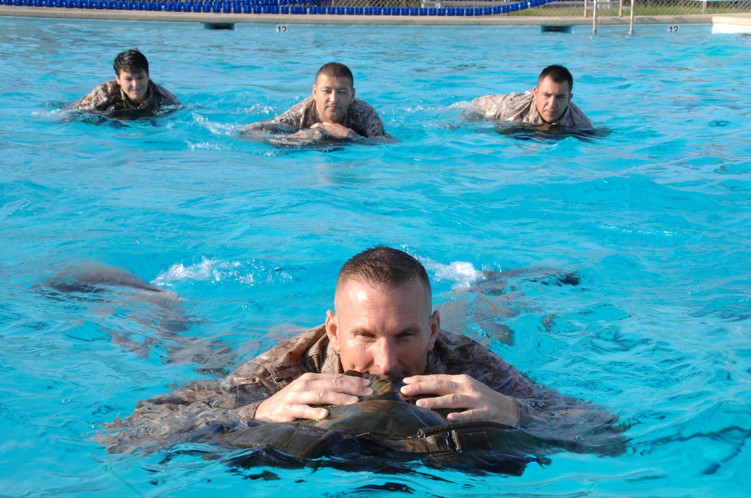 Marines use their packs as floatation devices during their annual swim qualification at Marine Corps Logistics Base Albany’s Base Pool, July 28 – Aug. 1. Ninety-eight Marines completed their training with 72 earning the Water Survival-Basic qualification and 26 receiving the Water Survival-Intermediate qualification. 