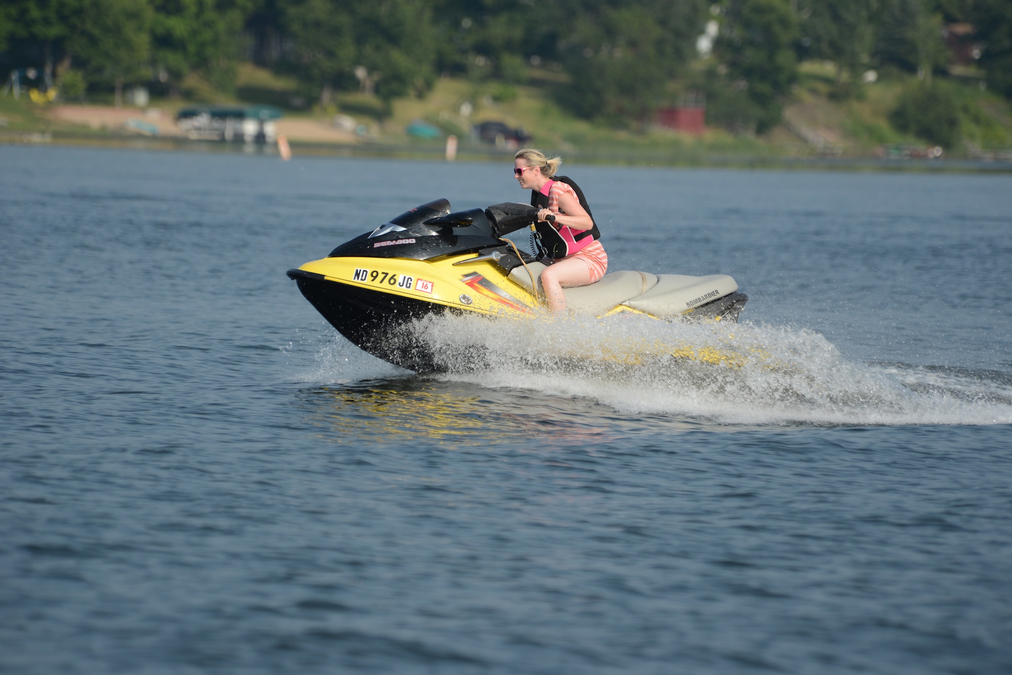 Tami Imlay rides a jet ski across the surface of Lake Maud, Minnesota, Aug. 1, 2014. Imlay is the surviving widow of Capt. Francis D. Imlay, who died in an F-15 crash in Southwest Asia March 28, 2012. She is the guest of husband and wife team Lt. Col. Micaela Brancato, and Lt. Col. Matthew Brancato, both of the 119th Wing, who operate Holbrook Farms Retreat and are hosting widows of U.S. military members who lost their lives while serving their country. The Brancatos are providing the retreat vacation in an effort to offer a relaxing break for the grieving widows. (U.S. Air Force photo/Senior Master Sgt. David H. Lipp)