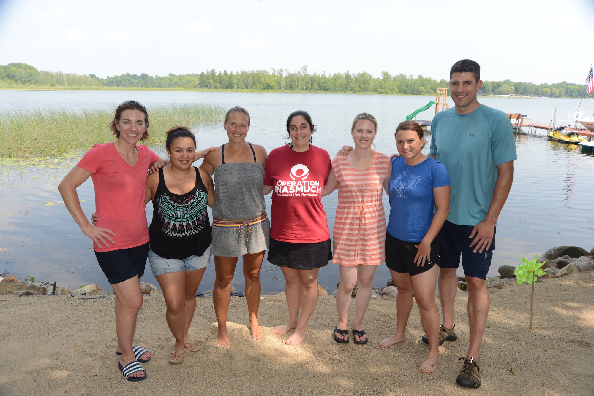 Husband and wife team Lt. Col. Micaela Brancato, left, and Lt. Col. Matthew Brancato, right, pose for a photo with their guests of Holbrook Farms Retreat from left to right Sonia Cazarez, Sarah Merwin, Leigh Giglio, Tami Imlay and Dana Lyon, as they relax at neighboring Maud Lake, Minn., Aug. 1, 2014. The guests of the Brancatos are widows of U.S. military members who lost their lives while serving their country. (U.S. Air Force photo/Senior Master Sgt. David H. Lipp)