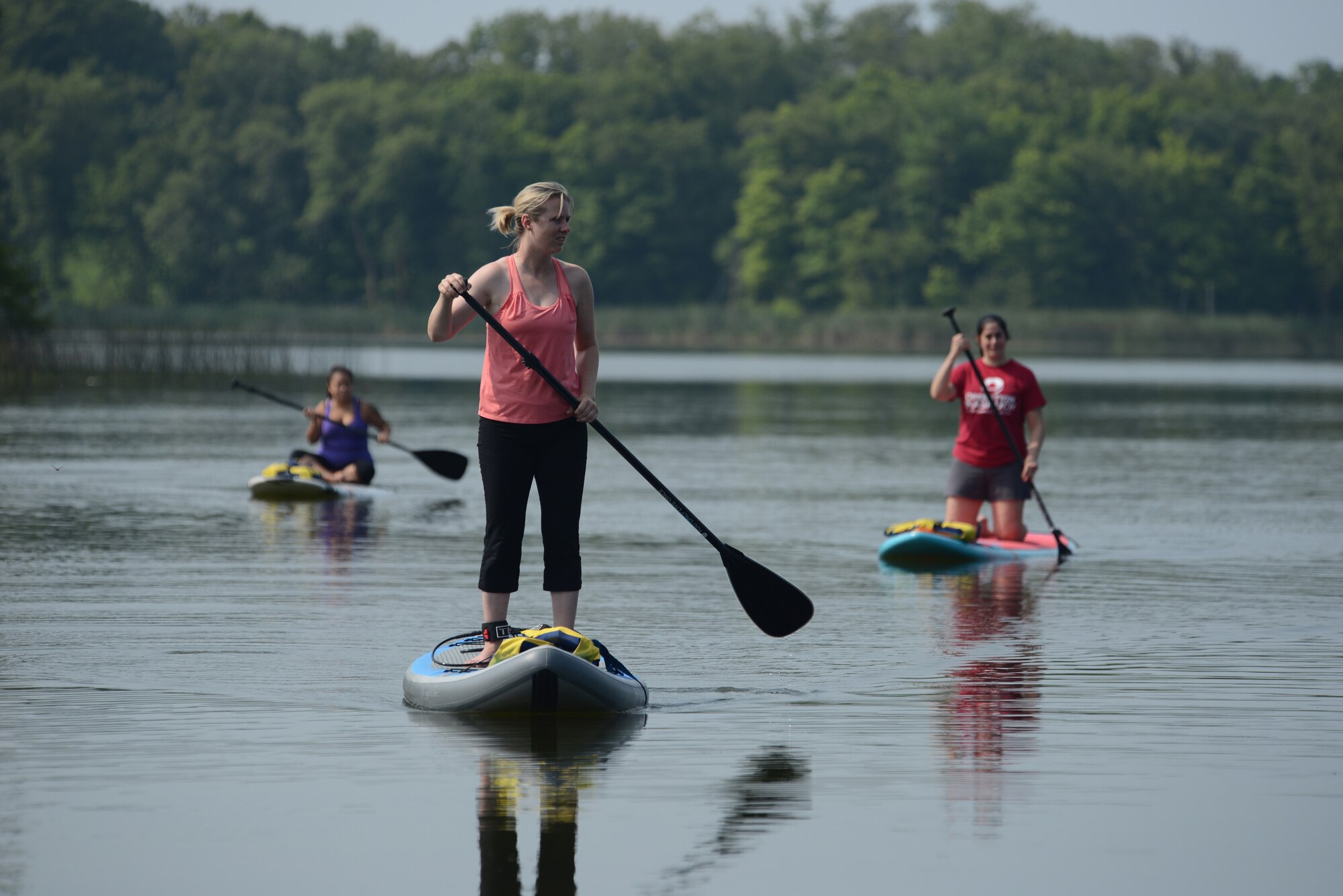 (From left to right) Sonia Cazarez, Tami Imlay and Leigh Giglio practice maneuvering paddleboards on the calm water of Holbrook Lake, Minn., Aug. 1, 2014, during a retreat for widows of U.S. military members who lost their lives while serving their country. The Holbrook Farms Retreat is hosted by husband and wife Lt. Col. Matthew Brancato and Lt. Col. Micaela Brancato, both in the 119th Wing. (U.S. Air Force photo/Senior Master Sgt. David H. Lipp)