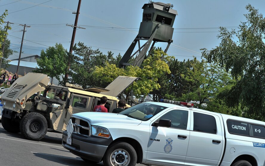 Members from the 92nd Security Forces Squadron set up a few displays to include a watch tower, Humvee, patrol vehicle and Military Working Dog demos in support of the National Night Out event held in Spokane Valley, Washington, Aug. 5, 2014. National Night Out is an annual event throughout the United States designed to heighten awareness of crime and drug prevention, strengthen neighborhood spirit and build partnerships with police. (U.S. Air Force photo by Staff Sgt. Alexandre Montes/Released)