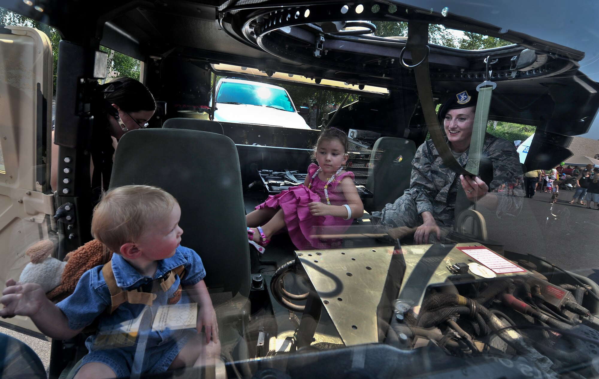 Senior Airman Brianne Berg lets local children experience a tour inside of a Humvee during a National Night Out event held in Spokane Valley, Washington, Aug. 5, 2014. Berg is a patrolman with the 92nd Security Forces Squadron at Fairchild Air Force Base, Washington. National Night Out is an annual event throughout the United States designed to heighten awareness of crime and drug prevention, strengthen neighborhood spirit and build partnerships with police. (U.S. Air Force photo by Staff Sgt. Alexandre Montes/Released)
