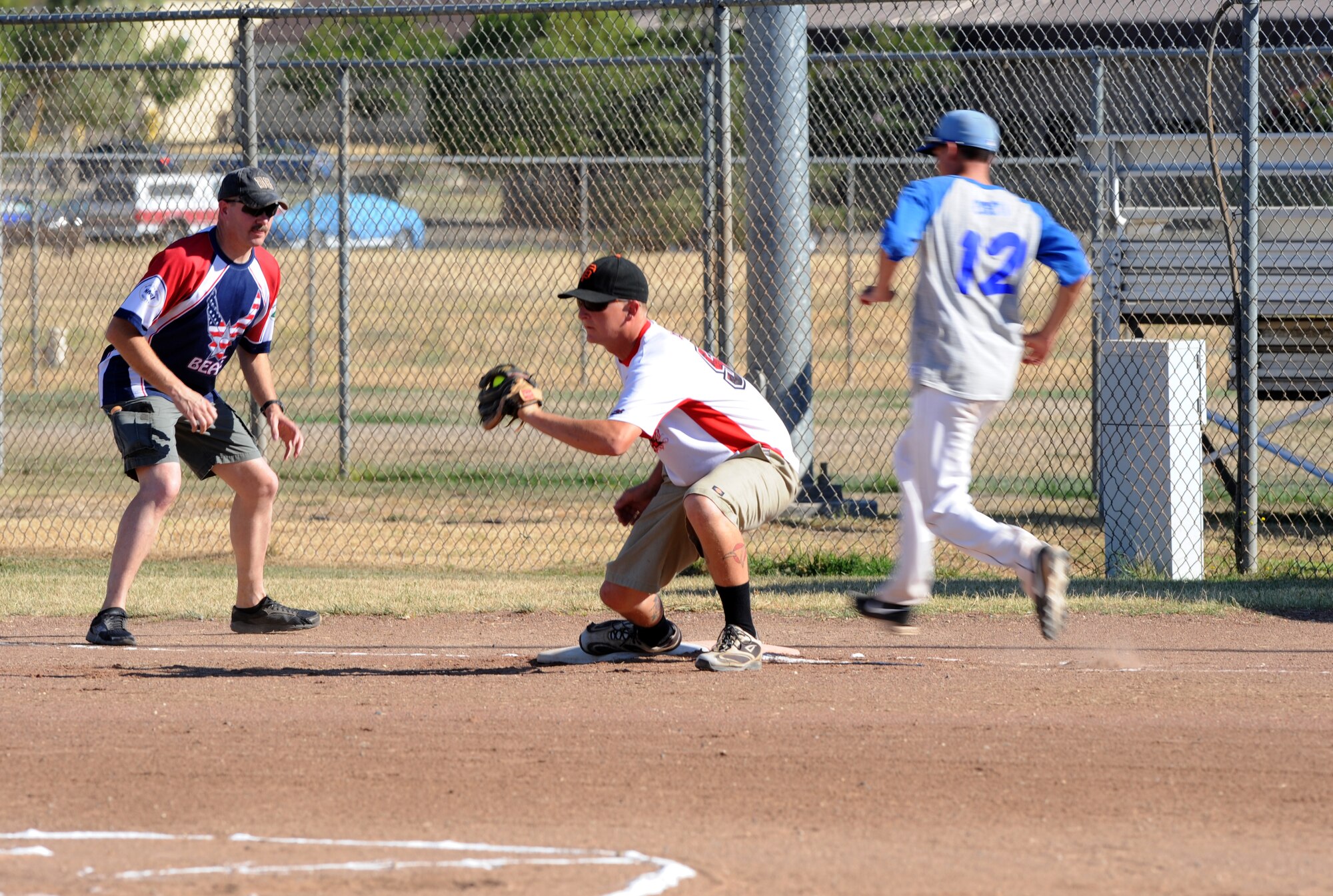 Staff Sgt. Blake Anderson, 9th Munitions Squadron, catches a softball at first base during the 2014 Intramural Softball Championships at O’Malley Field on Beale Air Force Base, Calif., July 31, 2014. 9th MUNS defeated 13th Intelligence Squadron, 19-4. (U.S. Air Force photo by Staff Sgt. Robert M. Trujillo/Released)