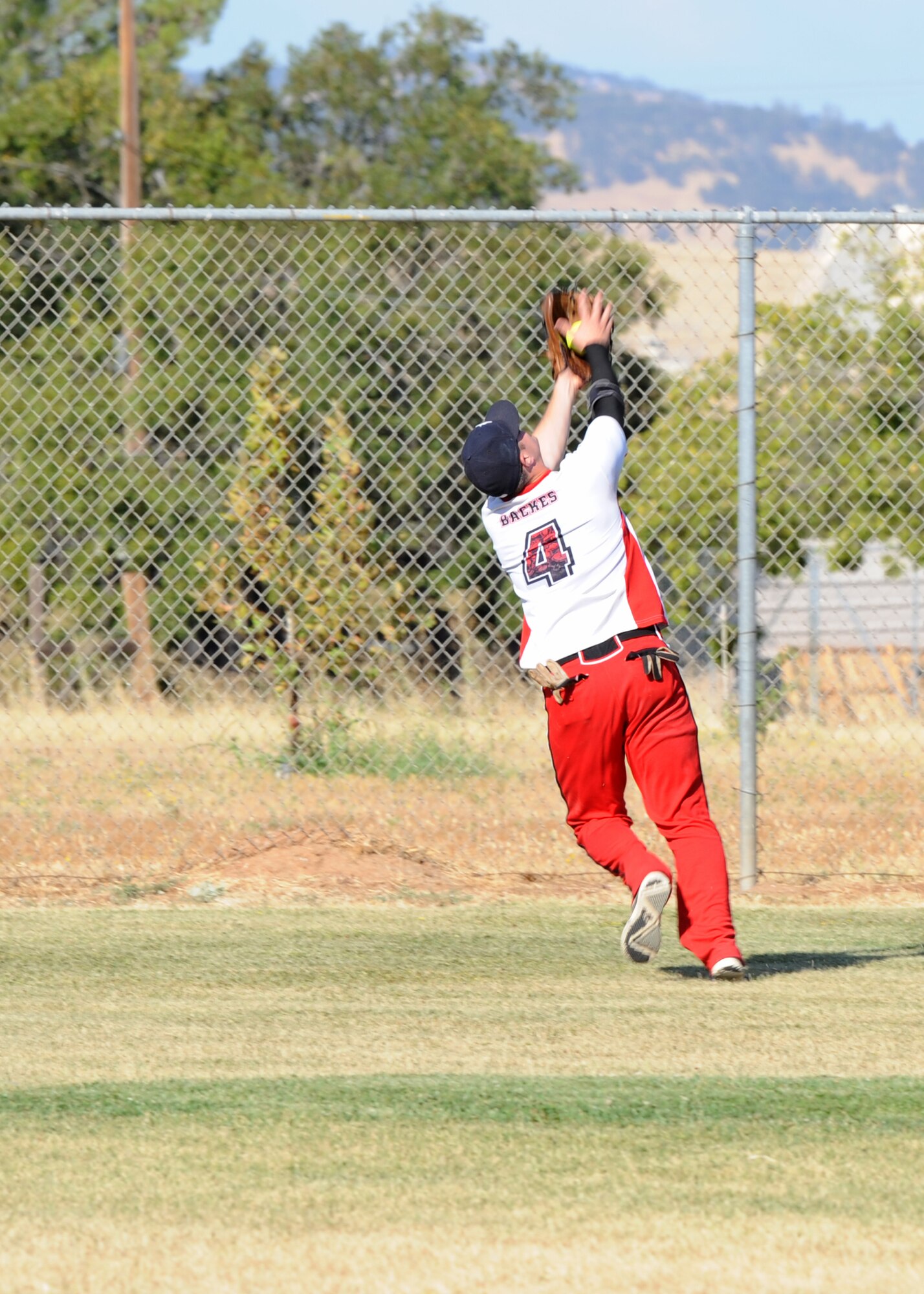 Tech. Sgt. Benjamin Backs, 9th Munitions Squadron, makes an over-the-shoulder catch during the 2014 Intramural Softball Championships at O’Malley Field on Beale Air Force Base, Calif., July 31, 2014. 9th MUNS defeated 13th Intelligence Squadron, 19-4. (U.S. Air Force photo by Staff Sgt. Robert M. Trujillo/Released)
