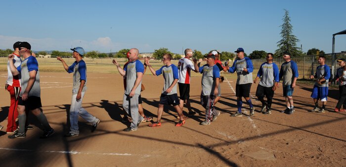 Members of the 9th Munitions Squadron and the 13th Intelligence Squadron congratulate each other during the conclusion of the 2014 Intramural Softball Championships at O’Malley Field on Beale Air Force Base, Calif., July 31, 2014. 9th MUNS defeated 13th Intelligence Squadron, 19-4. (U.S. Air Force photo by Staff Sgt. Robert M. Trujillo/Released)