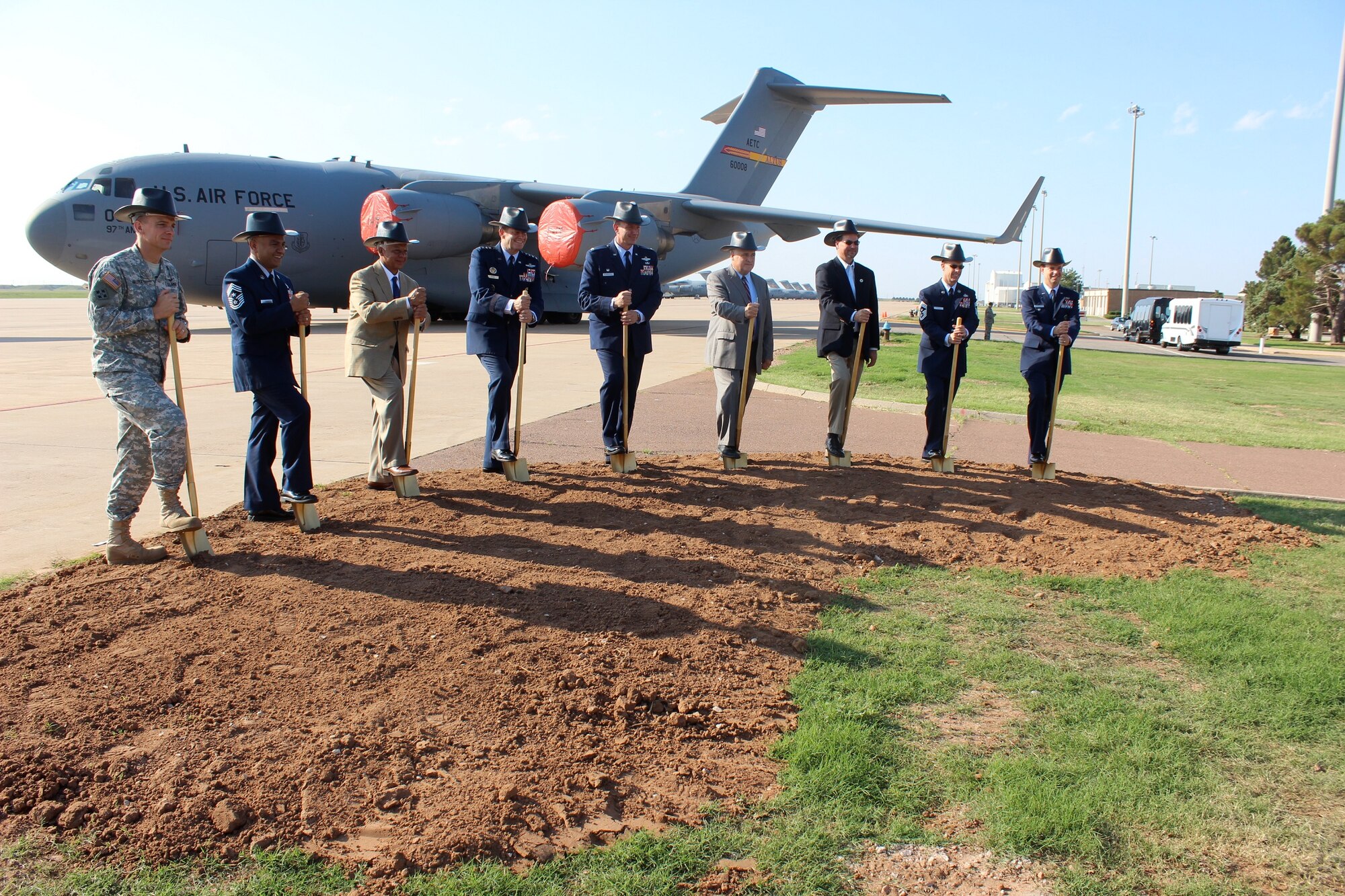 ALTUS AIR FORCE BASE, Okla. – Members of the official party, including the commander of Air Education and Training Command Gen. Robin Rand and 97th Air Mobility Wing Commander Col. Bill Spangenthal, break ground for new KC-46 Pegasus construction projects during a ceremony Aug. 7, 2014. In Southwest Oklahoma fashion, the group wore cowboy construction hats for the dig. The new construction is estimated at $56 million and will include a flight training center, a fuselage training facility, new aircraft hangars and renovations for a combined squadron operations and aircraft maintenance unit facility. (Courtesy photo)