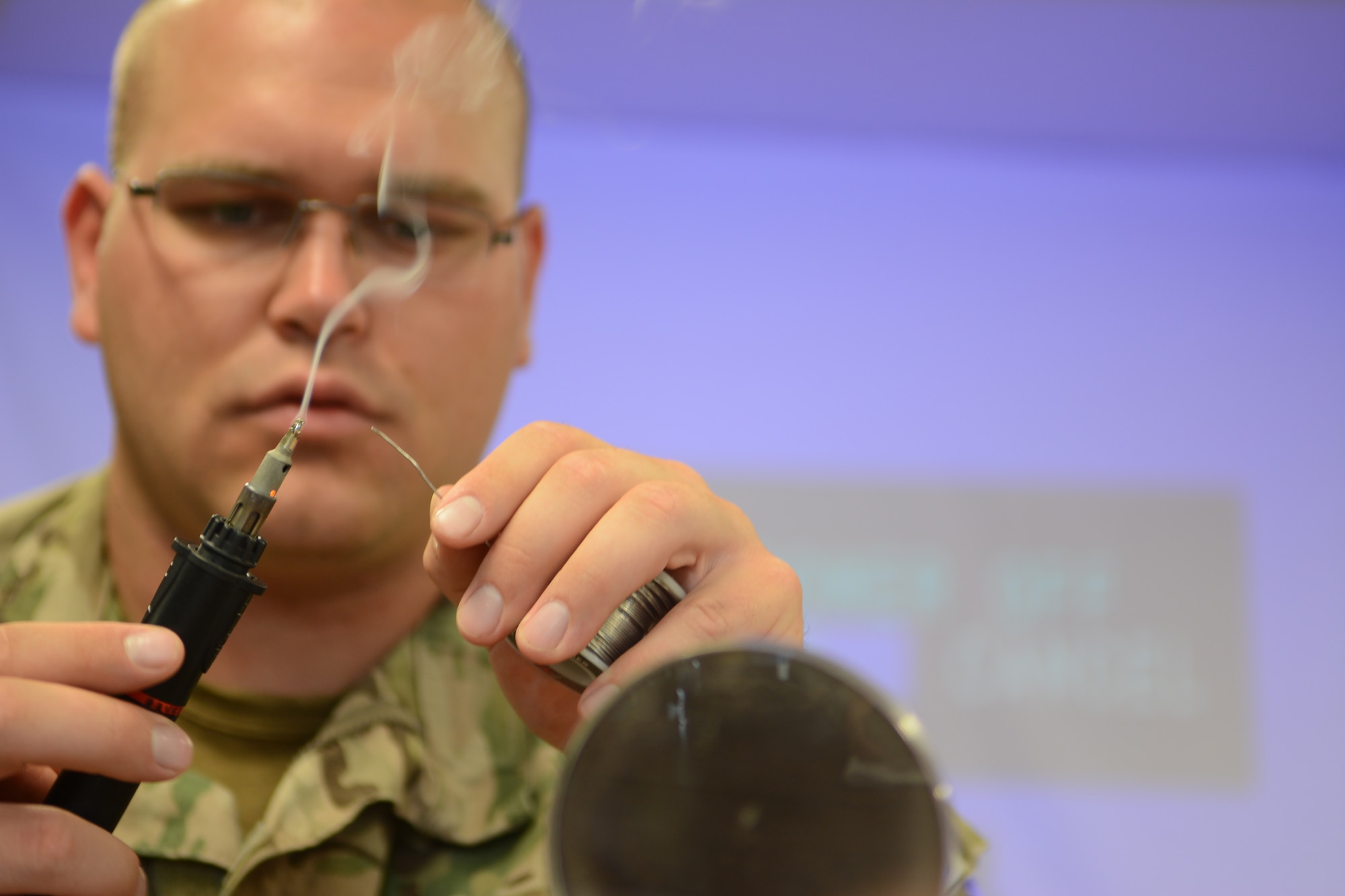 Tech. Sgt. Erich Sanford, 115th Fighter Wing explosive ordnance disposal flight, solders wire together to make improvised explosive ordnances to use during the 2014 PATRIOT exercise at Volk Field Air National Guard Base, Wis., July 19, 2014. The IEDs were used to test the knowledge of younger Airmen as they were later tasked to safely disassemble them. (Air National Guard photo by Senior Airman Andrea F. Liechti)