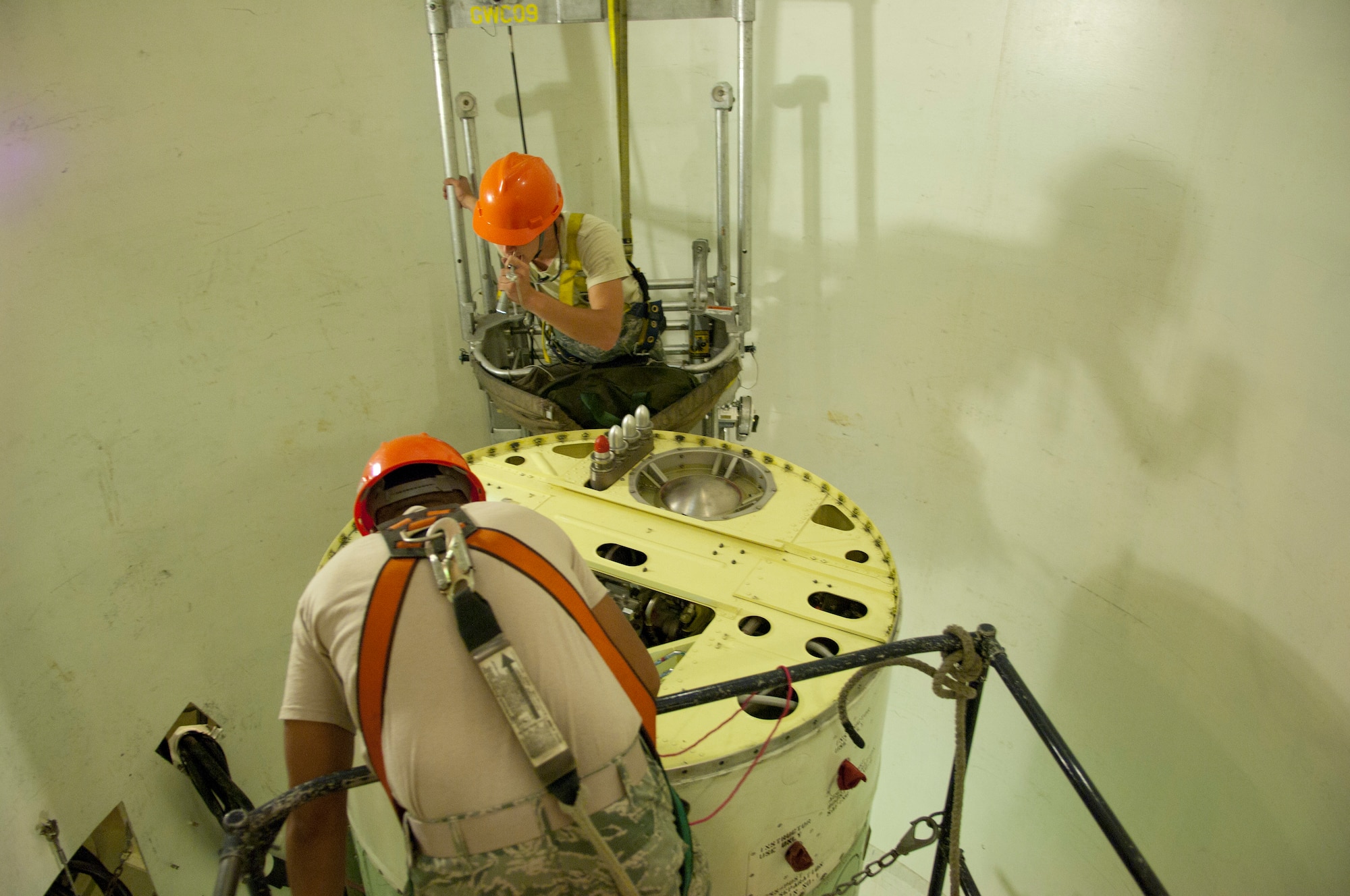 Airman 1st Class Michael Ocampo and Airman 1st Class Leslie Friestad, both in the 90th Missile Maintenance Squadron, perform a visual inspection of a propulsion system rocket engine in the U-01 practice launch facility on F.E. Warren Air Force Base, Aug. 4 2014. Airmen who will be tasked with missile maintenance pay close attention to detail to ensure the operation ability of the Minuteman III weapons system.  (U.S. Air Force photo by Lan Kim)