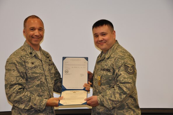 Lt. Col. John Graver, 304th Rescue Squadron commander, presents Tech. Sgt. Carl Valentine the Air Force Commendation Medal, Aug. 2, 2014. The 304th RQS is trained and equipped to deploy combat rescue officers, pararescuemen, and support personnel worldwide in support of U.S. national security interests. (U.S. Air Force photo/Staff Sgt. Daniel Delgado)