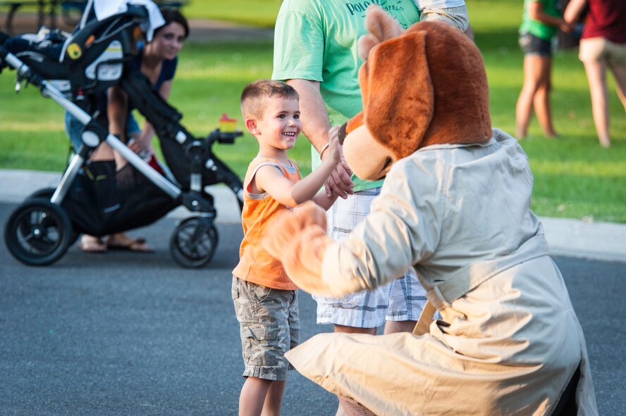 Scruff McGruff high fives a Fairchild youth during the installation’s National Night Out celebration at Fairchild Air Force Base, Washington, Aug. 5, 2014. The event is held across the country to help prevent crime and drugs from entering “our” neighborhoods. (U.S. Air Force photo by Staff Sgt. Benjamin W. Stratton/Released)