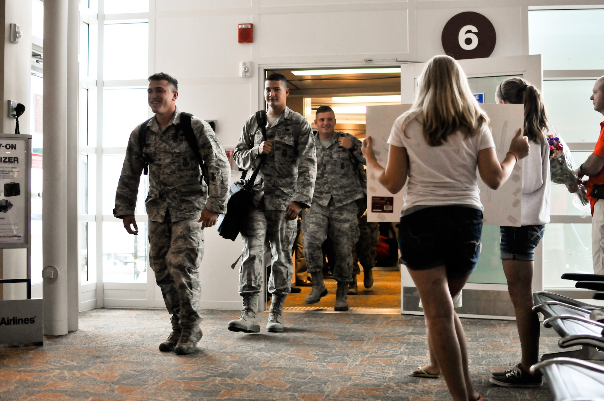 From left, U.S. Air Force Airman 1st Class Tyler N. Woolridge, Senior Airman Christian A. Downen and Airman 1st Class Jordan A.D. Sanford, specialists with the 182nd Security Forces Squadron, arrive home at the General Wayne A. Downing Peoria International Airport in Peoria, Ill., Aug. 6, 2014. They and 15 Illinois Air National Guardsmen deployed to Southwest Asia for seven months in support of Operation Enduring Freedom. They were assigned to the 405th Expeditionary Security Forces Squadron overseas, where they were responsible for law enforcement and security missions in the region’s global war on terror. (U.S. Air National Guard photo by Staff Sgt. Lealan Buehrer/Released)