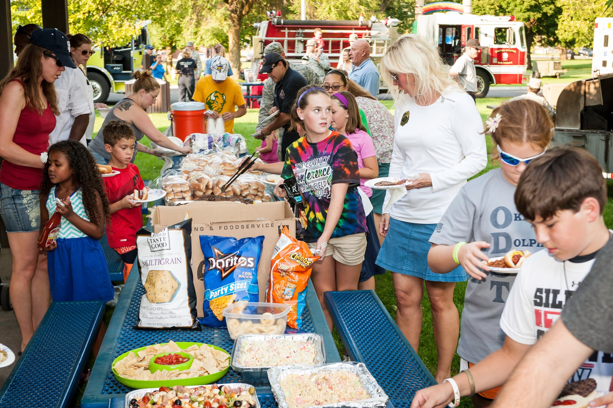 Fairchild families take part in a community potluck during the installation’s National Night Out celebration at Fairchild Air Force Base, Washington, Aug. 5, 2014. Balfour Beatty provided hamburgers and hotdogs, asking that families bring a dish to share with their neighbors. The event is held across the country to help prevent crime and drugs from entering “our” neighborhoods. (U.S. Air Force photo by Staff Sgt. Benjamin W. Stratton/Released)
