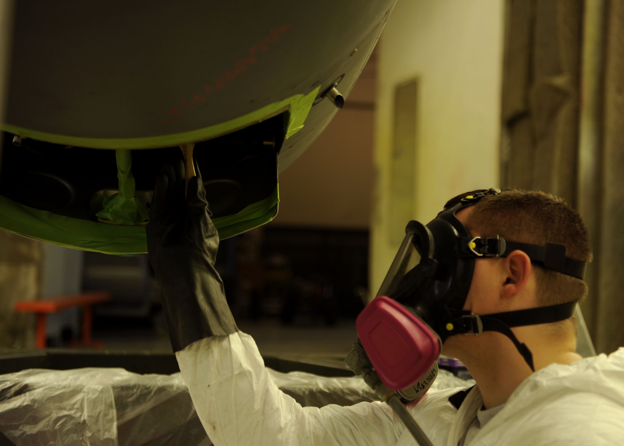 Airman 1st Class Jacob Chastain, a 19th Maintenance Squadron structural maintenance journeyman, applies paint stripper to the bottom of the oil cooler on a C-130 engine July 17, 2014, at Little Rock Air Force Base, Ark. The oil cooler should not have paint on it because the paint acts like insulation and will not allow it to cool properly. (U.S. Air Force photo by Airman 1st Class Scott Poe) 