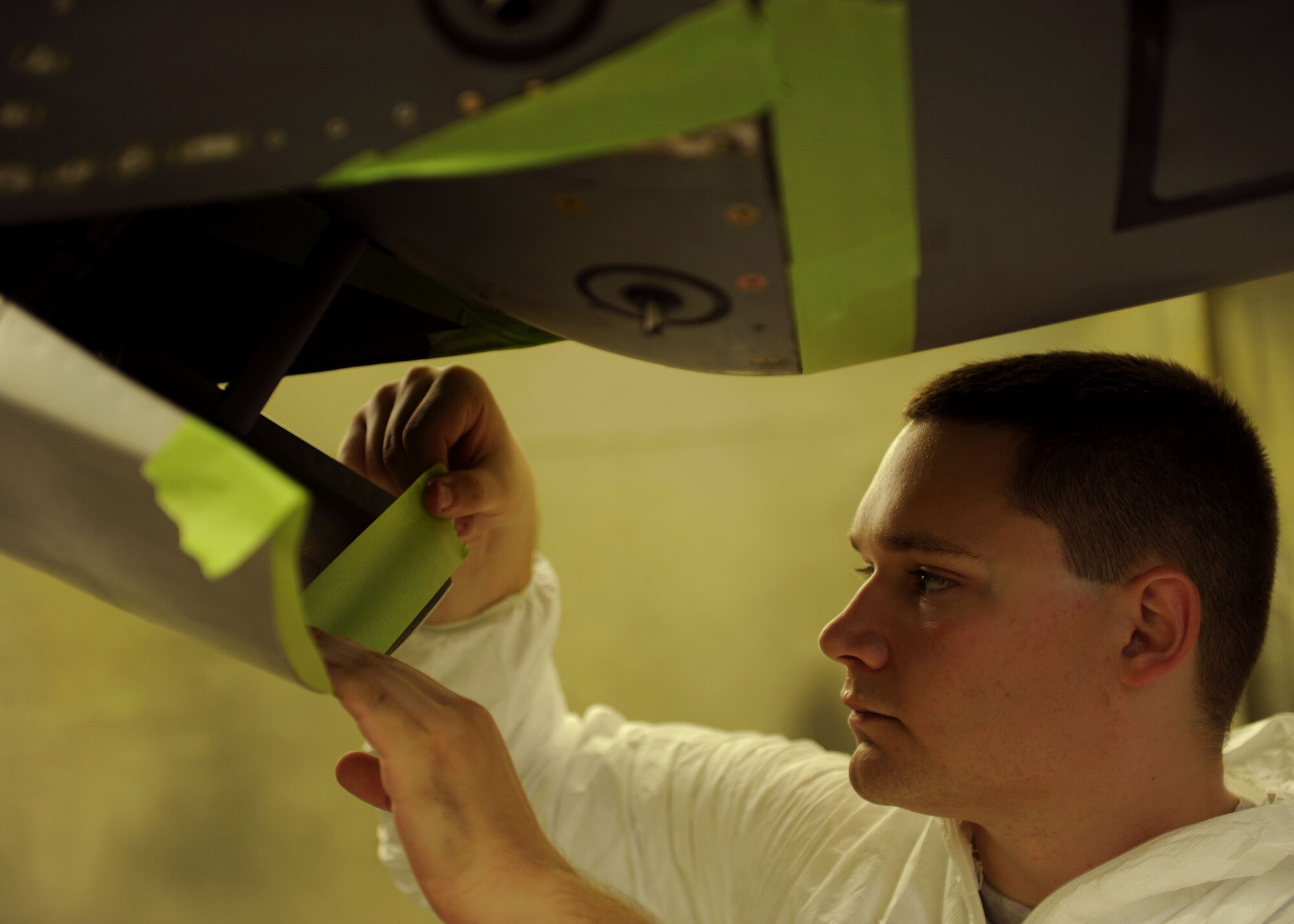 Airman 1st Class Jacob Chastain, a 19th Maintenance Squadron structural maintenance journeyman, prepares an area for sanding, primer and then paint July 17, 2014, at Little Rock Air Force Base, Ark. Multiple procedures go into preparing materials for paint including masking, stripping the old paint, sanding and wiping down the material before the primer is applied. (U.S. Air Force photo by Airman 1st Class Scott Poe)