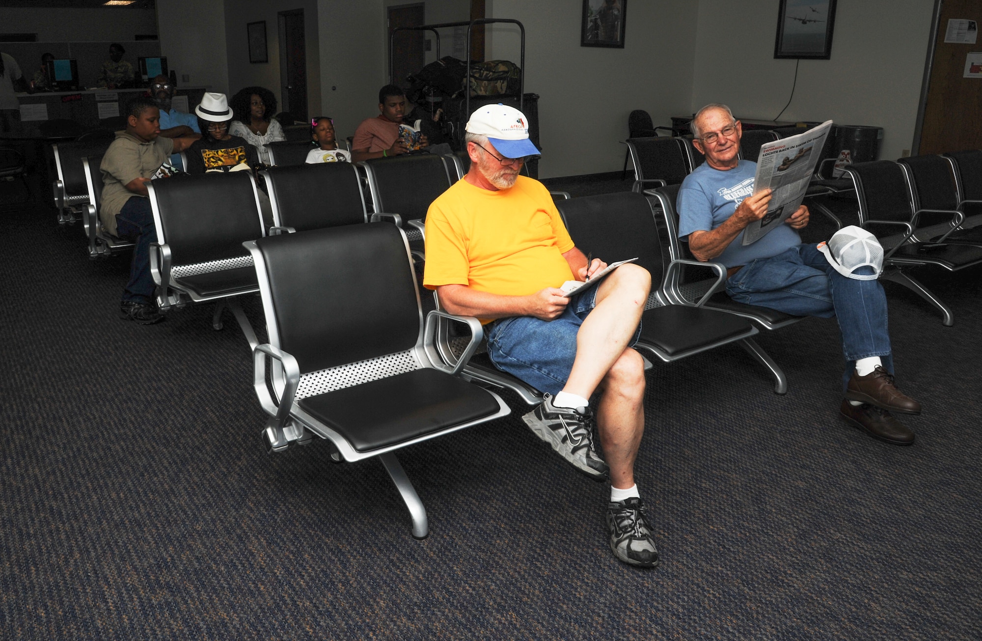 Customers sit in the Little Rock Air Force Base passenger terminal August 6, 2014, at Little Rock Air Force Base, Ark. Based on the amount of space available after mission priority cargo has been fulfilled, authorized military members, dependents, retirees, and Department of Defense civilians can fly on DOD owned or operated aircraft. (U.S. Air Force photo by Airman 1st Class Mercedes Muro)