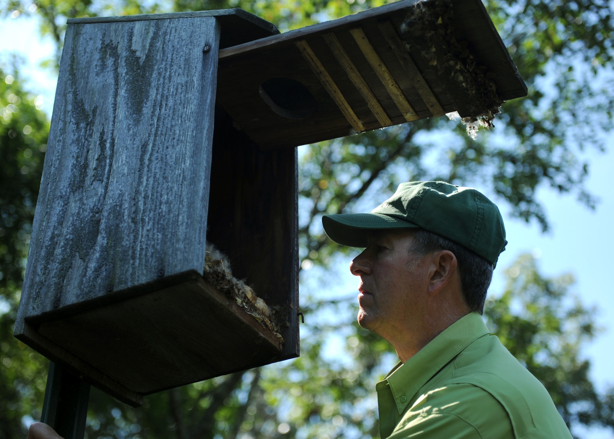 James Popham, the 19th Civil Engineer Squadron natural resources manager, inspects a wood duck house for signs of use July 29, 2014, at Little Rock Air Force Base, Ark. Keeping the houses clean and in good shape ensures the return of the ducks each year. (U.S. Air Force photo by Airman 1st Class Scott Poe) 