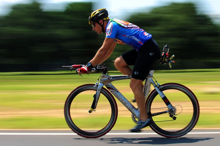 U.S. Air Force Maj. Joel Dopson, 9th Air Force chief of flight safety, rides his bicycle on Patrol Road at Shaw Air Force Base, S.C., Aug. 7, 2014. Dopson has completed approximately 25 triathlons and one Ironman competition over the last eight years. Dopson plans on competing in an Ironman competition in October. (U.S. Air Force photo by Airman 1st Class Michael Cossaboom/Released)