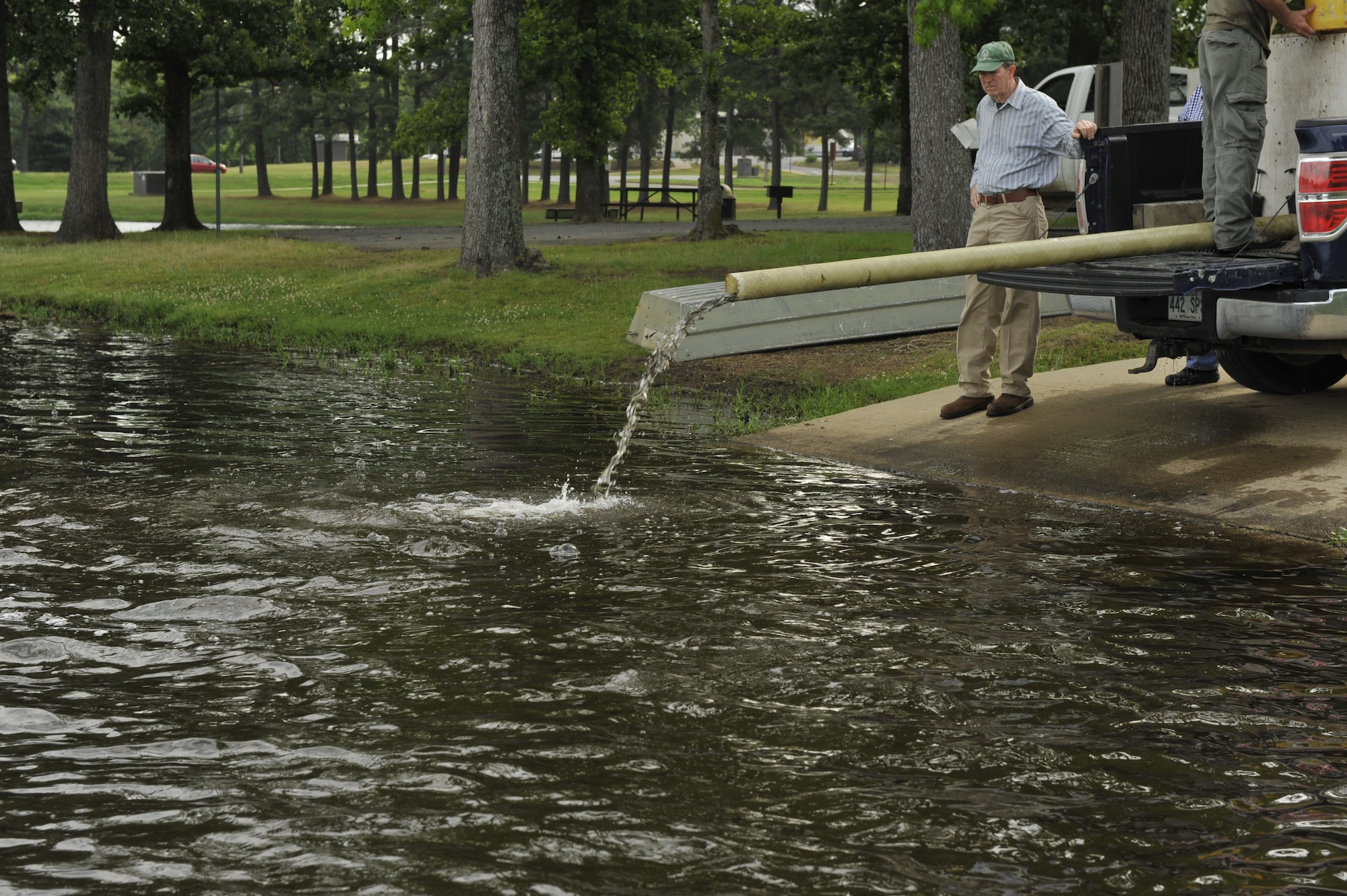 James Popham, the 19th Civil Engineer Squadron natural resources manager, observes as fish are released into the base lake May 21, 2014, at Little Rock Air Force Base, Ark. Minnows are stocked to feed the largemouth bass and other wildlife in and around the lake. (U.S. Air Force photo by Airman 1st Class Scott Poe)