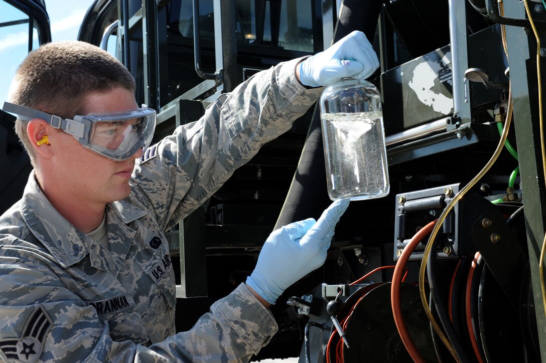Senior Airman Derek Brannan, 28th Logistics Readiness Squadron fuels laboratory technician, checks for particulates in fuel drawn from a fuels truck at Ellsworth Air Force Base, S.D., July 30, 2014. Technicians collect and sample fuel, ensuring it meets specifications for use. (U.S. Air Force photo by Senior Airman Hailey R. Staker/Released)