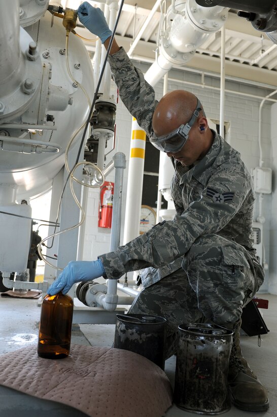 Senior Airman Bradley Sutter, 28th Logistics Readiness Squadron fuels laboratory technician, draws fuel from a fuel tank at Ellsworth Air Force Base, S.D., July 30, 2014. Fuel samples are collected and then tested by technicians to ensure fuel is clean and contaminant free. (U.S. Air Force photo by Senior Airman Hailey R. Staker/Released)