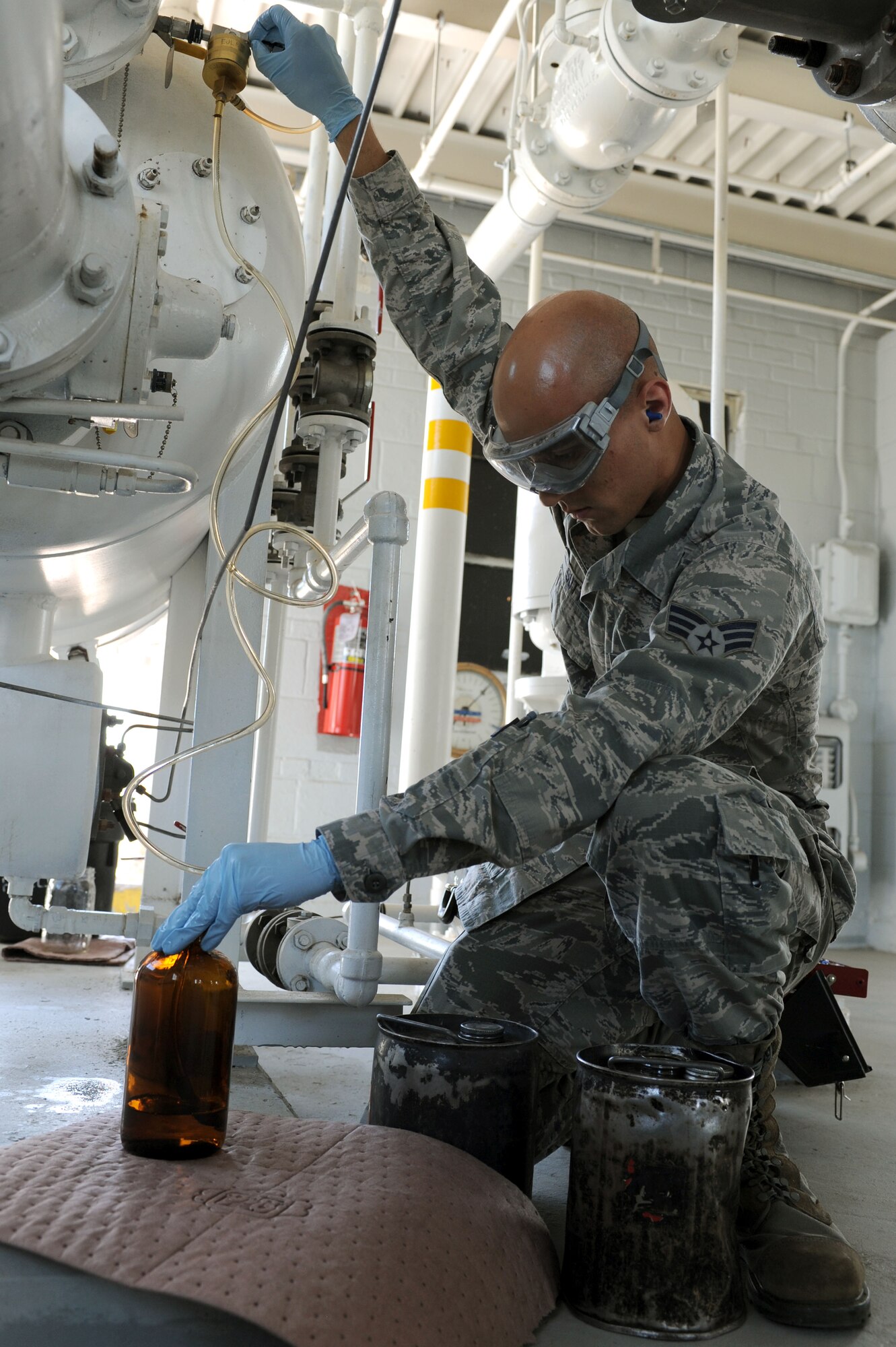 Senior Airman Bradley Sutter, 28th Logistics Readiness Squadron fuels laboratory technician, draws fuel from a fuel tank at Ellsworth Air Force Base, S.D., July 30, 2014. Fuel samples are collected and then tested by technicians to ensure fuel is clean and contaminant free. (U.S. Air Force photo by Senior Airman Hailey R. Staker/Released)