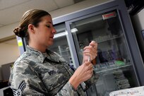 Senior Airman Kelly Boos prepares to administer multiple vaccinations Aug. 6, 2014, at the Joint Base San Antonio-Randolph Immunizations Clinic. Boos is an aerospace medical technician. (U.S. Air Force photo/Desiree N. Palacios)