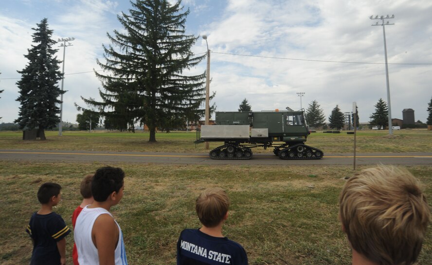 Children from the Northeast Youth Center of Spokane watch the Tucker all-terrain vehicle in action at Fairchild Air Force Base, Washington, Aug. 1, 2014. The children were touring the base to further their understanding of the survival facilities for their military theme week. (U.S. Air Force photo by Airman 1st Class Sam Fogleman/Released)