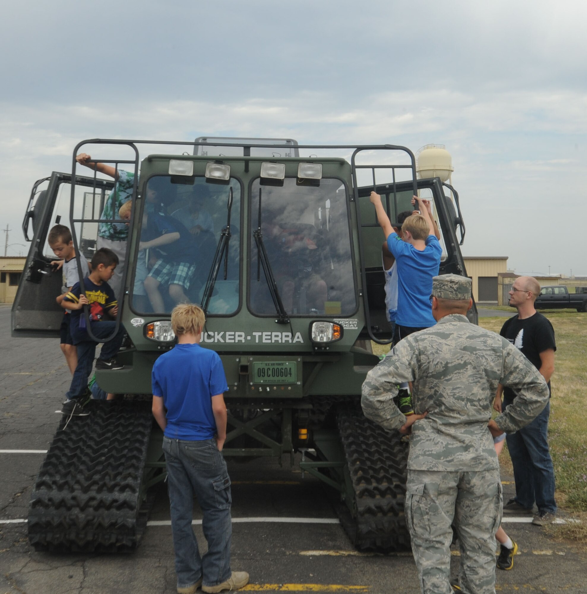 Children from the Northeast Youth Center of Spokane tour the Tucker all-terrain vehicle at Fairchild Air Force Base, Washington, Aug. 1, 2014. The vehicle is part of the operational fleet of the 336th Training Support Squadron. The children were touring the Survival School area of the base so they could experience military missions. (U.S. Air Force photo by Airman 1st Class Sam Fogleman/Released)