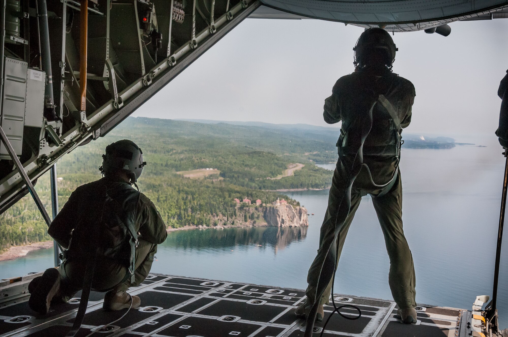Staff Sgt. Cody Schroeder (left) and Tech. Sgt. Pat Woods, 96th Airlift Squadron loadmasters, look out over Split Rock Lighthouse from a C-130 aircraft during an Employers' Day flight Aug. 2.  The annual event allows employers to see what their employees do during Unit Training Assembly weekends, learn more about the Reserve mission and gain a greater understanding of what it means for their employee(s) to be a member of the 934 AW.  (U.S. Air Force photo/Staff Sgt. Cherish Chavez)