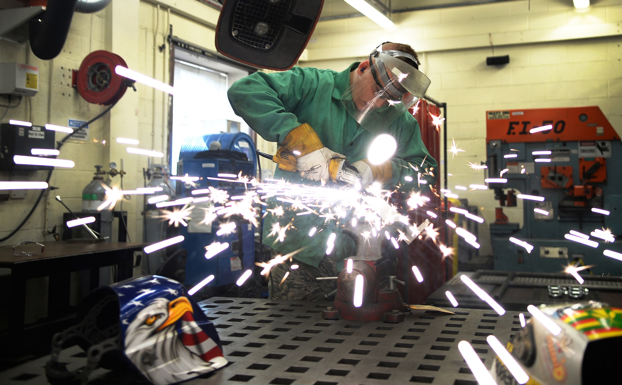 Airman 1st Class Cody Birnschein, 48th Equipment Maintenance Squadron aircraft metals technician, grinds a block of titanium down for a project at Royal Air Force Lakenheath, England, Aug. 5, 2014. The fabrication work completed by the metals technology technicians combines both machining and welding. (U.S. Air Force photo by Staff Sgt. Emerson Nuñez/Released)  