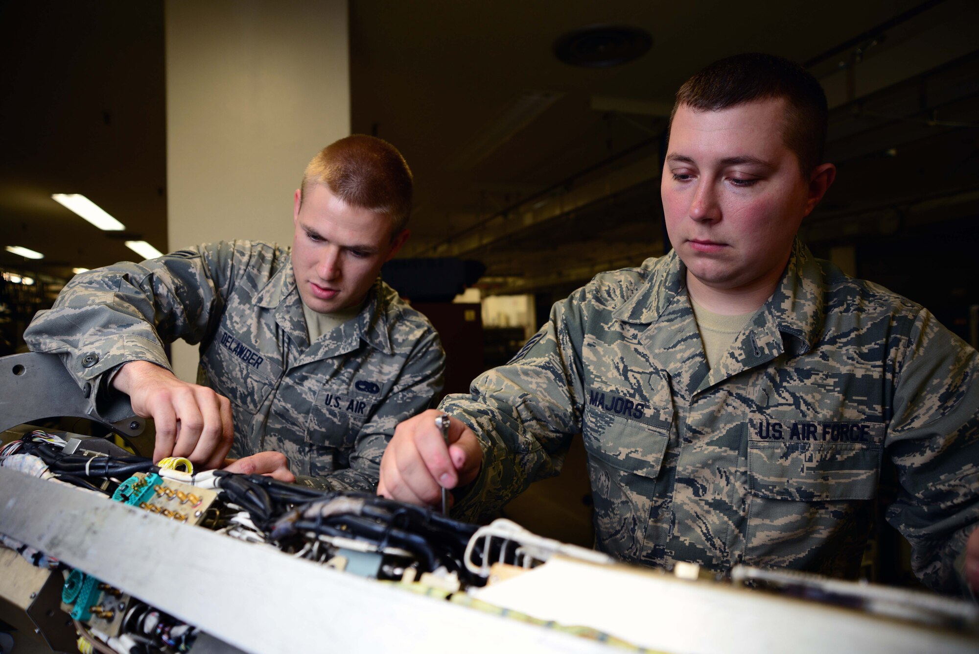 Airman 1st Class Jacob Delawder, left, and Staff Sgt. Crayge Majors, 35th Maintenance Squadron electronic warfare team members, work on upgrade training on an AN/ALQ-184 electronic countermeasure pod at Misawa Air Base, Japan, July 25, 2014. Every one of 44 F-16 Fighting Falcons at Misawa AB must have one of these 760-pound pods ready and servicable at any moment. (U.S. Air Force photo/Senior Airman Derek VanHorn)