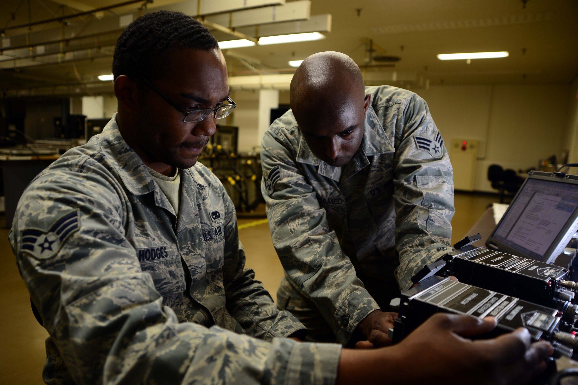 Senior Airmen Michael Hodges and Abshir Hagimohamed, 35th Maintenance Squadron avionics intermediate shop, test frequencies on a line-replacable unit at Misawa Air Base, Japan, July 25, 2014. In the intermediate shop, Hodges and Hagimohamed work on around 30 LRUs and repair around 200 annually. (U.S. Air Force photo/Senior Airman Derek VanHorn)