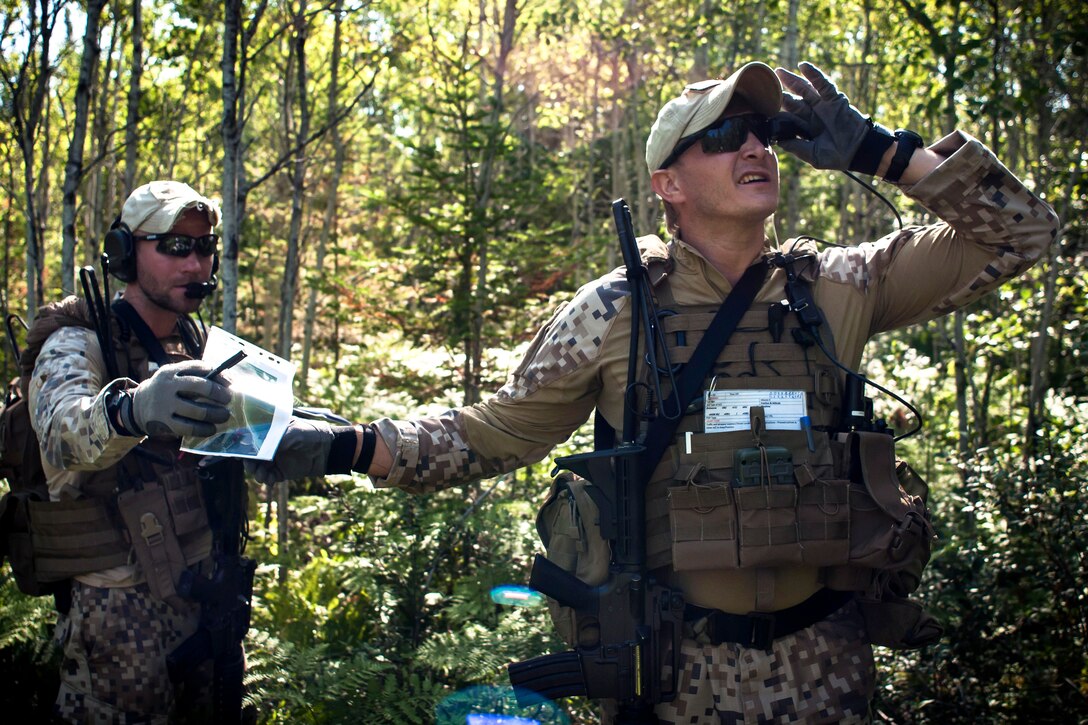 Latvian Sgt. Janis Savickis, right, looks through a remotely operated video-enhanced receiver as Latvian Capt. Armands Rutkis hands him a map during Operation Northern Strike 2014 near Rogers City, Mich., Aug. 5, 2014.
