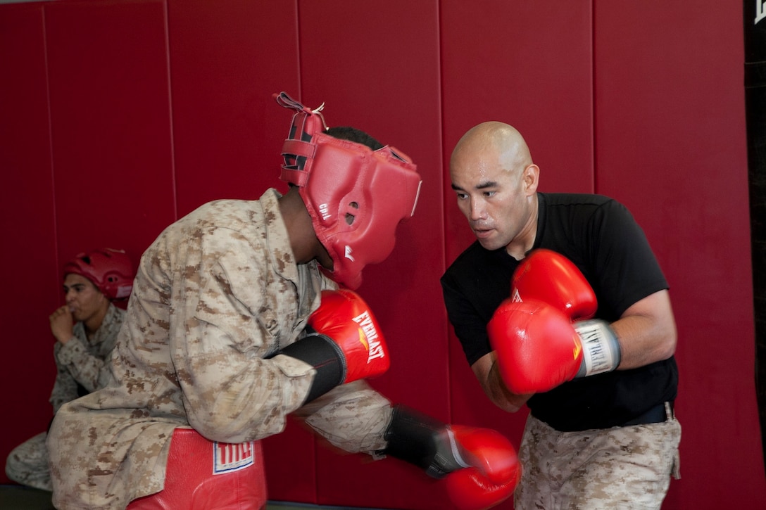 Staff Sgt. Eduardo R. Guzman, right, defends against a blow from Cpl. Terrance J. Slaughter, left, July 14 at Marine Corps Air Station Futenma’s McCutcheon Gym during a Martial Arts Instructor course. The Marine Corps Martial Arts Program was officially established in 2002, and the principle of hand-to-hand combat in the Marine Corps has existed since the Corps was established. Guzman is a Chicago, Illinois, native and aviation supply specialist with Marine Air Logistics Squadron 36, Marine Aircraft Group 36, 1st Marine Aircraft Wing, III Marine Expeditionary Force. Slaughter is a Tomball, Texas, native and air support operator with Marine Air Support Squadron 2, Marine Air Control Group 18, 1st MAW, III MEF. 