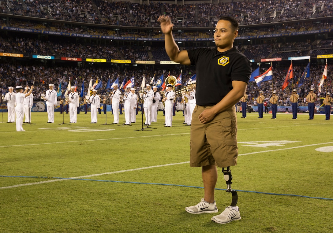 Marcus Chischilly, member of the Wounded Warrior Battalion West, waves while on the field during the 26th Annual Salute to the Military game at Qualcomm Stadium, San Diego, Aug. 7. Chischilly and other members from the Wounded Warrior Battalion West were honored during the halftime show performance. 